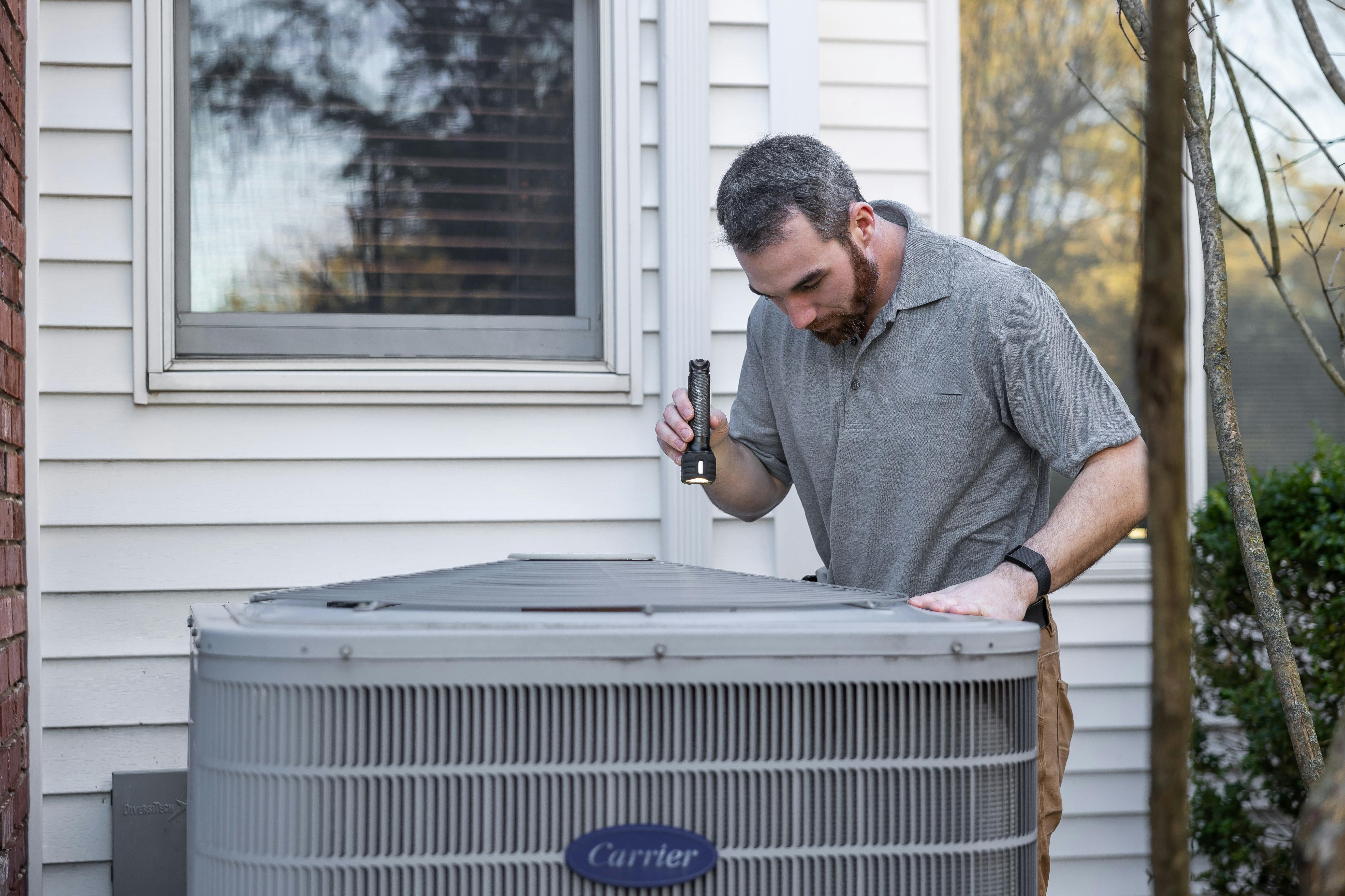 Professional HVAC technician servicing Carrier air conditioning unit in San Francisco